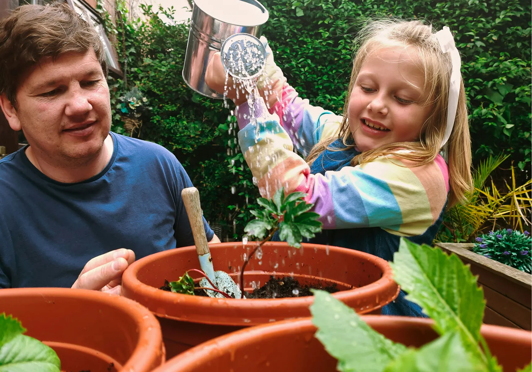 A parent and child gardening together at home